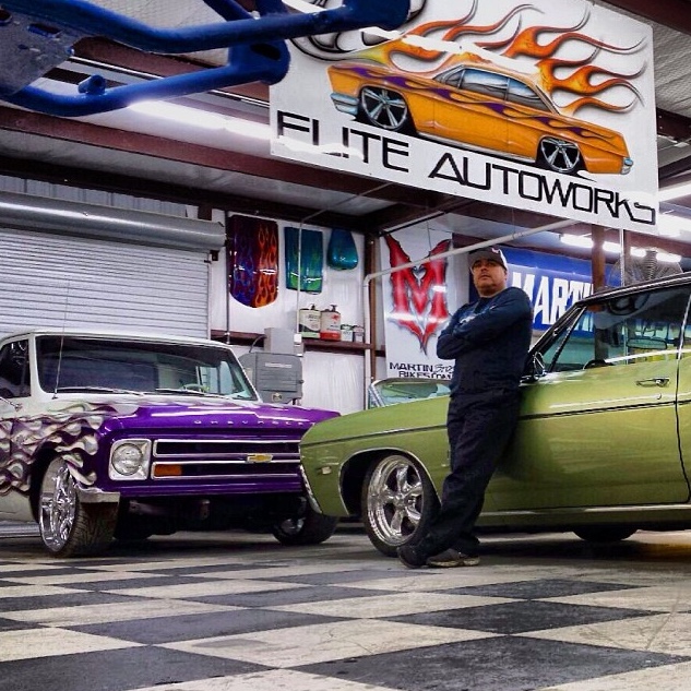 Shorty standing next to a truck in his shop